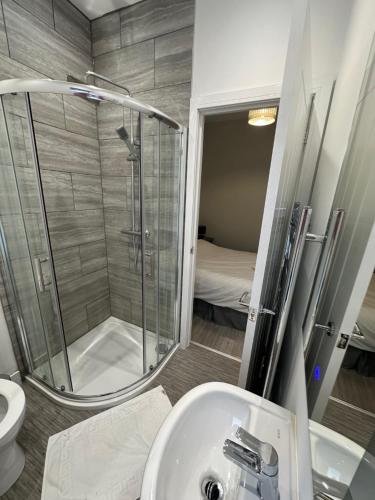 La salle de bains est pourvue d'une douche, d'un lavabo et de toilettes. dans l'établissement Colville Apartments, à Peterborough