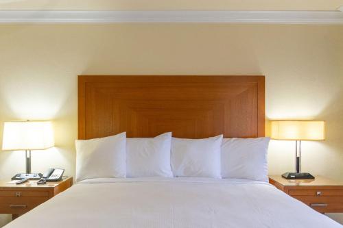 a large bed with white pillows and two lamps at Inn at San Luis Obispo in San Luis Obispo