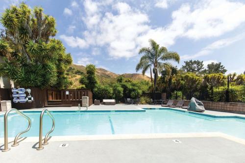 a swimming pool in a resort with palm trees at Inn at San Luis Obispo in San Luis Obispo
