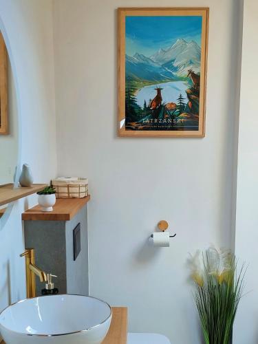 a bathroom with a painting hanging on the wall at Domki Hygge Tatra Luxury Chalet in Murzasichle