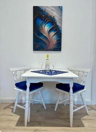 a white table with two wine glasses and a painting at Wagner Villa 902 with free private parking in Budapest