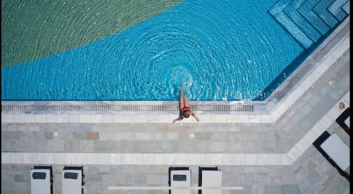 una persona buceando en una piscina de agua en Elysia Park Ameliya 202, en Pafos
