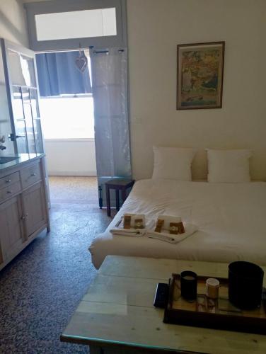 - une chambre avec un lit et une table avec deux assiettes dans l'établissement Face à la mer, appartement pour 4 personnes sur la rive droite, à Palavas-les-Flots