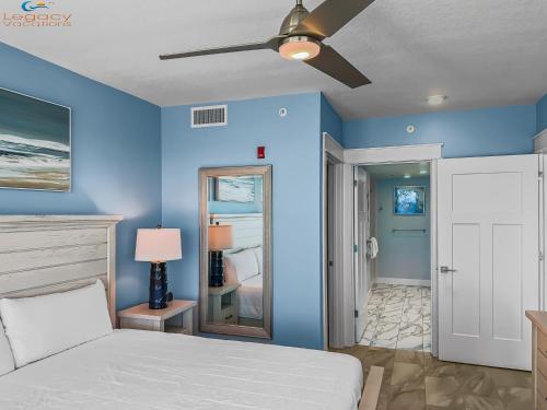 a bedroom with blue walls and a ceiling fan at blu #606 Luxury 2 Bd Beachfront Condo in Fort Walton Beach