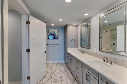 a bathroom with two sinks and a large mirror at blu #606 Luxury 2 Bd Beachfront Condo in Fort Walton Beach