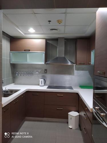 una cucina con armadi in legno e piano cottura. di 1Bedroom Furnished Apartment a Dubai