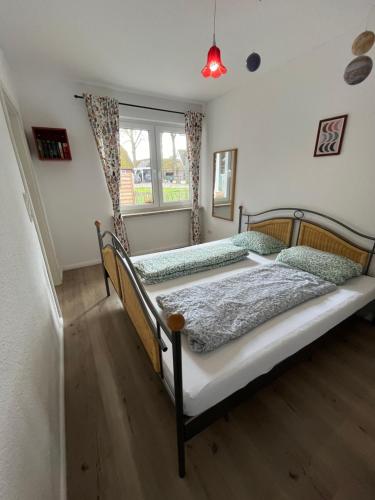 a bedroom with two beds and a window at Ferienwohnung am Nordpfad Zevener Geest in Zeven