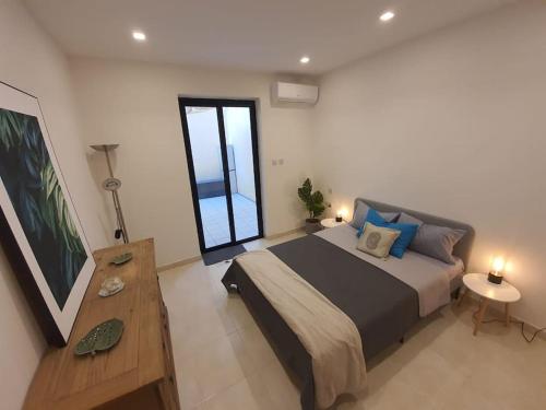 ein Schlafzimmer mit einem großen Bett und einem großen Fenster in der Unterkunft Spacious, Central & New 3-BR apartment. Wifi & AC in Is-Swieqi
