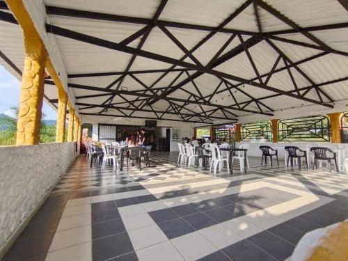 um pátio com mesas e cadeiras num edifício em Club Ecoturístico Las Cascadas de Pauna Boyacá em Pauna