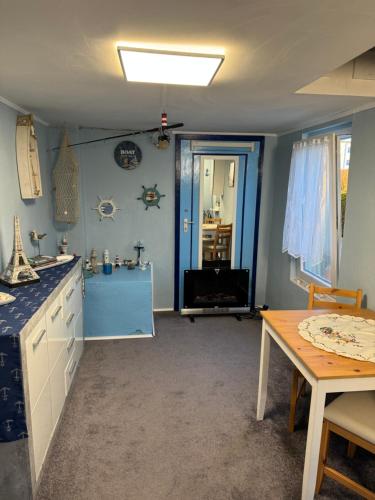 a kitchen with a table and a blue wall at Ostsee Ferienhaus mit Whirlpool in Wolgast
