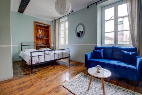 sala de estar con sofá azul y cama en le romantique, hyper centre, en Périgueux