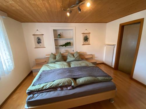 a bedroom with a large bed with a wooden ceiling at Rosenheim Apartments in Tires