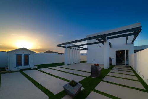 a white building with a sunset in the background at Villa Monarca in Costa Teguise