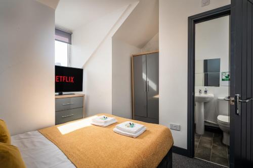 Private En-suite Room - Shared Living space & Kitchen - Wakefield - Central في ويكفيلد: غرفة نوم عليها سرير وفوط
