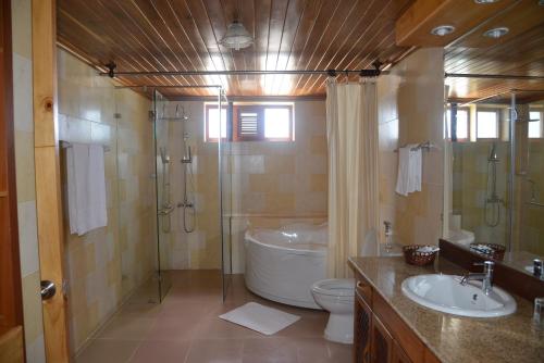 a bathroom with a tub and a toilet and a sink at Vinh Suong Seaside Hotel and Resort in Mui Ne