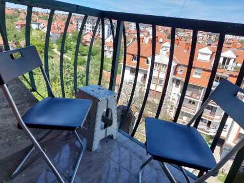 two chairs and a table on a balcony with a view at Apartman U CENTRU in Arandelovac