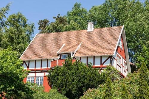 uma casa vermelha e branca no topo das árvores em Ferienhaus für 9 Personen und 1 Kind in Ängelhol, Südschweden Küste von Schonen em Ängelholm