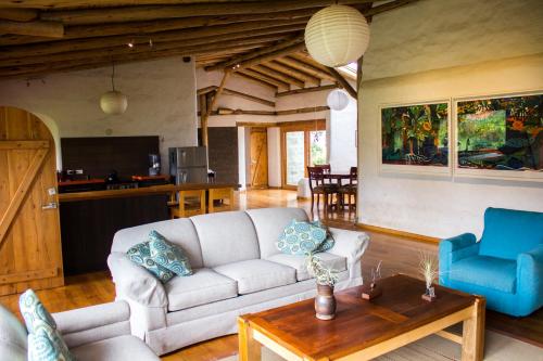 ein Wohnzimmer mit einem Sofa und einem Tisch in der Unterkunft Confortable casa de campo en el Atacazo, muy cerca de Quito in Tambillo