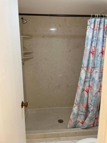 a shower with a shower curtain in a bathroom at Sunny Jupiter Villa in Jupiter