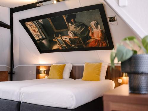 a room with two beds and a painting on the wall at Hotel de Koophandel in Delft