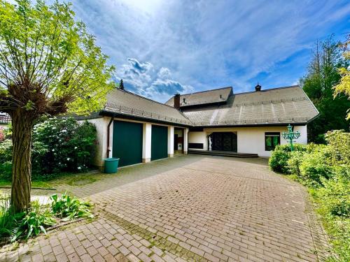 une maison avec une allée en briques devant elle dans l'établissement Luxury Spa Villa EMG Karlsruhe Baden-Baden Rastatt - Gernsbach, à Gernsbach