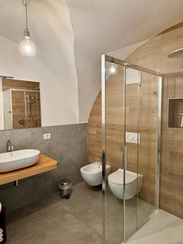 a bathroom with a glass shower and a sink at Eco Garda Hill in Tenno