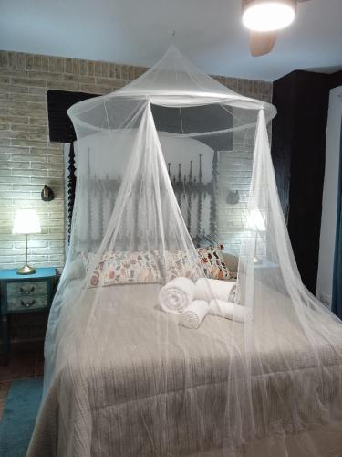 a bedroom with a canopy bed with towels on it at Casa Rural Montepinar in El Bosque