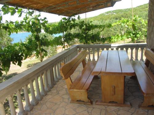 a wooden bench on a balcony with a view of the ocean at House Marta in Kraj