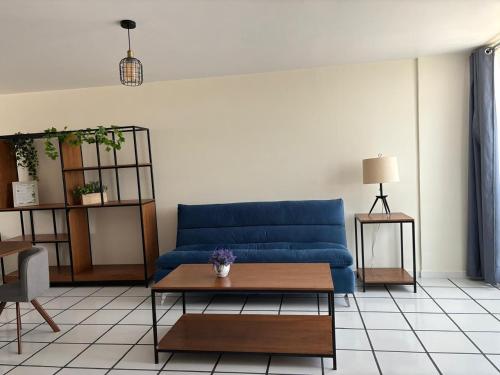 a living room with a blue couch and a table at El Encanto Lofts in Cuernavaca