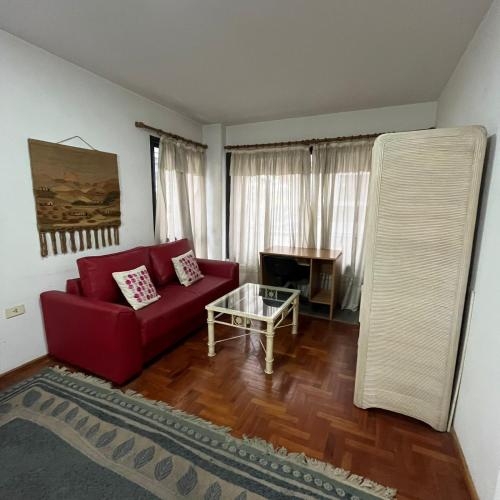 sala de estar con sofá rojo y mesa en Montevideo 20 Bis en Córdoba