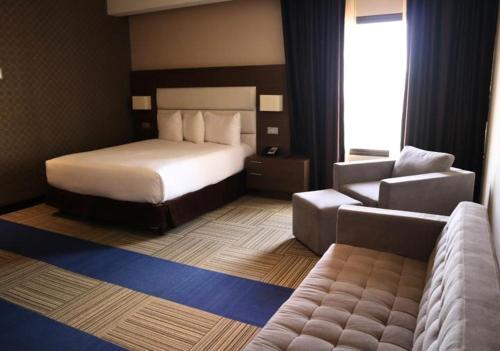 Habitación de hotel con cama y sofá en Eurobuilding Hotel & Suites Coro en Santa Ana de Coro