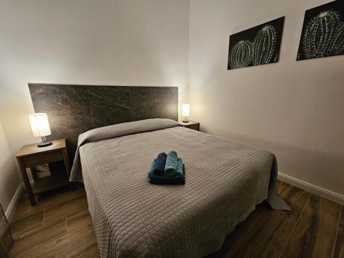 a bedroom with a bed with a pair of shoes on it at La Casa di Ray e Anto in Cassibile