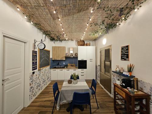 a kitchen and dining room with a table and blue chairs at La Casa di Ray e Anto in Cassibile