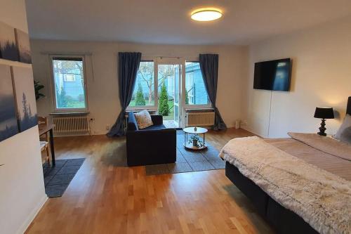 a large bedroom with a bed and a couch and windows at Apartment with garden near metro! in Stockholm