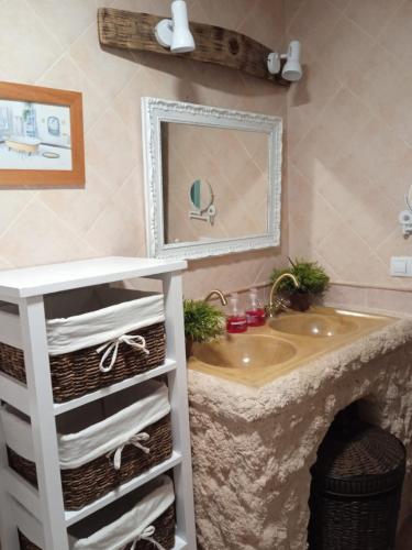 a bathroom with a sink and a mirror and towels at Casa Rural Montepinar in El Bosque