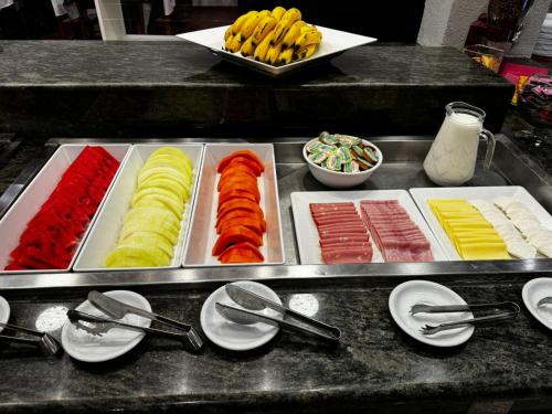 a buffet line with different types of food on trays at Hotel Minorus in Aparecida