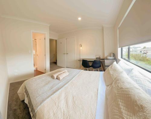 um quarto com uma cama branca e uma grande janela em 4 En-suite Rooms Town House em Hamilton