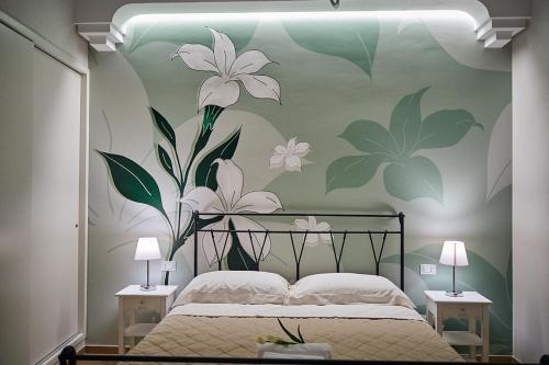 um quarto com uma cama com flores na parede em B&B TRINACRIA CACCAMO - LUXURY ROOMS em Caccamo