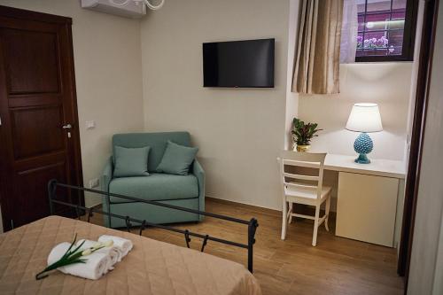 um quarto de hotel com uma cadeira e uma mesa e um quarto em B&B TRINACRIA CACCAMO - LUXURY ROOMS em Caccamo