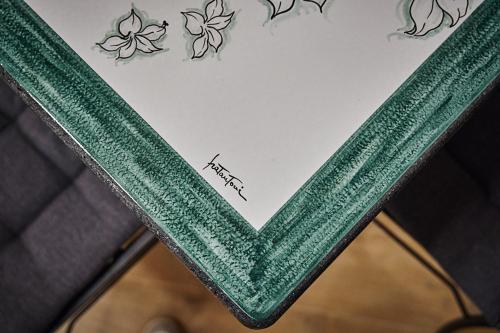 a white paper with green writing on top of a table at Trinacria Caccamo - Luxury Rooms in Caccamo