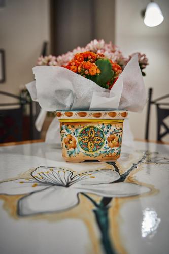 a vase filled with flowers sitting on a table at Trinacria Caccamo - Luxury Rooms in Caccamo