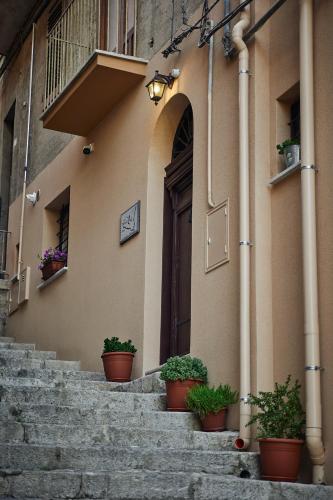 a building with potted plants sitting on the stairs at Trinacria Caccamo - Luxury Rooms in Caccamo