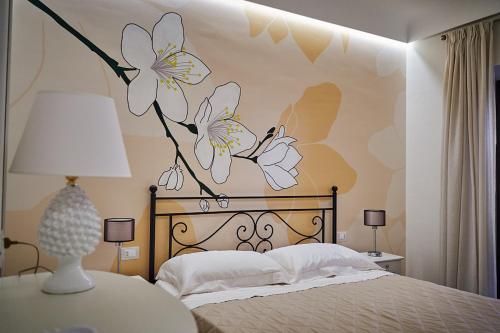 a bedroom with a bed with flowers painted on the wall at Trinacria Caccamo - Luxury Rooms in Caccamo