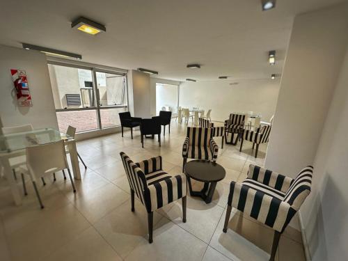 a waiting room with chairs and a table and a piano at Simplemente DUOMO in Córdoba