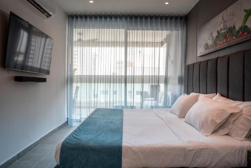 1 dormitorio con 1 cama grande y ventana grande en Tres habitaciones - Vista al Mar en Cartagena de Indias