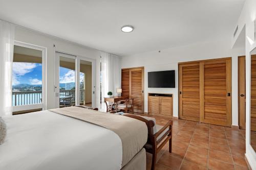 a bedroom with a large bed and a television at Las Casitas Village at El Conquistador in Fajardo