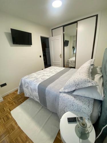 a bedroom with a bed with a mirror and a table at Apartamento El Rinconín in Cangas de Onís
