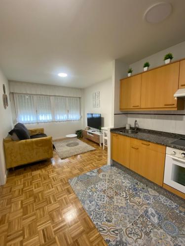 a living room with a kitchen and a living room with a couch at Apartamento El Rinconín in Cangas de Onís