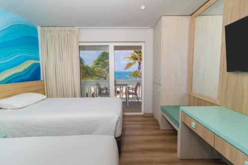 a hotel room with two beds and a view of the ocean at Hotel Bahia Sardina in San Andrés
