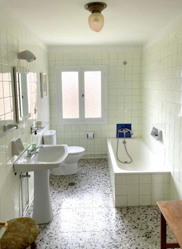 a white bathroom with a tub and a sink and a tub at El Violetu in Cue